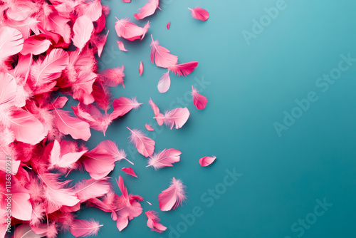 Colorful pink feathers scattered on a blue backdrop create a visually striking display of texture and softness photo