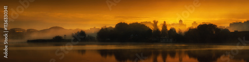 coastal cityscape in autumn foggy haze and orange-red light of morning glow and with reflection on water surface of lake. widescreen panoramic side view in 20x5 format