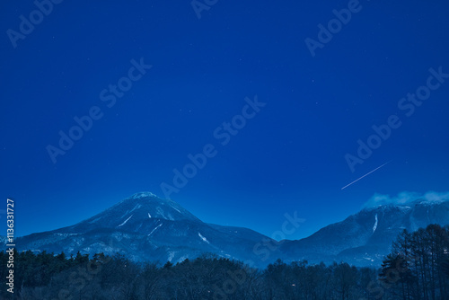 雪の蓼科山の青く嫌いな夜景と流れ星