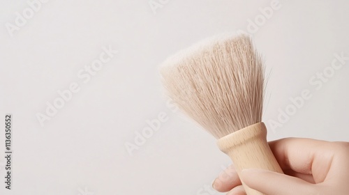 Hand Gently Brushing Dust off Delicate Object with Soft Lighting photo