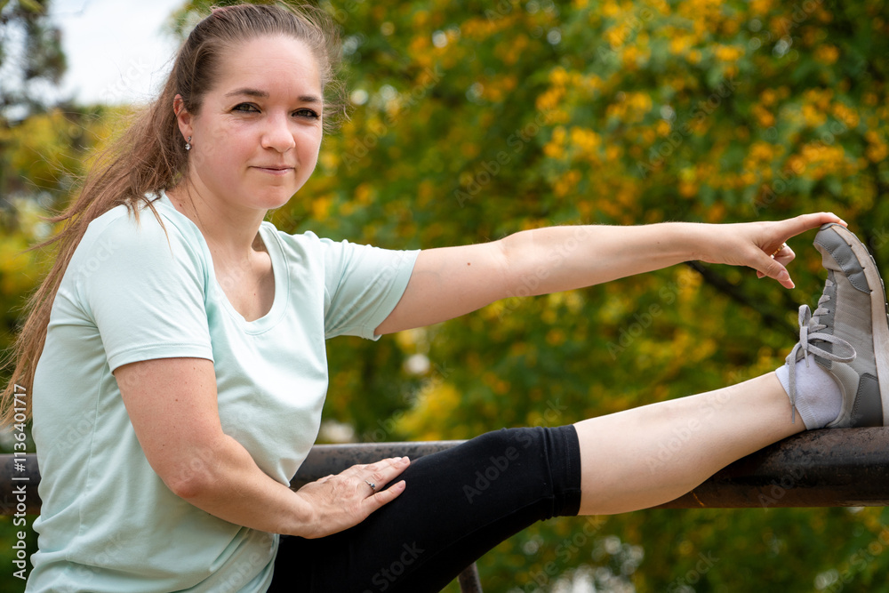 Mujer haciendo estiramientos de piernas luego de su entrenamiento al aire libre en el Parque de su ciudad Mujer haciendo estiramientos de piernas luego de su entrenamiento al aire libre en el Parque de su ciudad