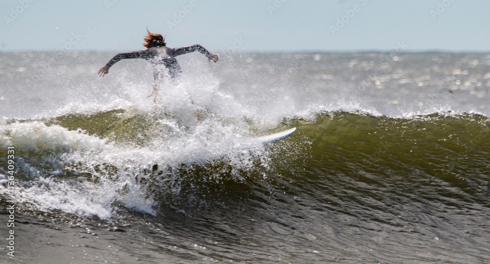 Surfer Showcases Skill While Riding a Powerful Wave on a Sunny Day at the Beach Surfer Showcases Skill While Riding a Powerful Wave on a Sunny Day at the Beach