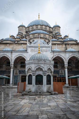 Istanbul Eminonu Yeni Cami in Turkey. Magnificent mosque with intricate domes and a serene courtyard, cloudy day