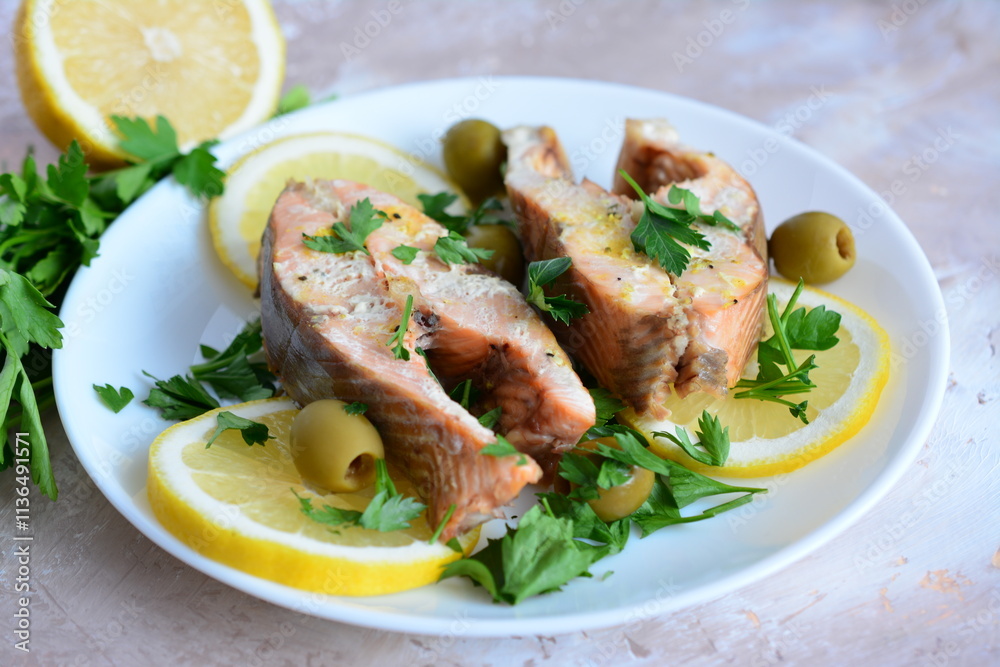 a plate of roasted fish steaks and lemon slices close up a plate of roasted fish steaks and lemon slices close up