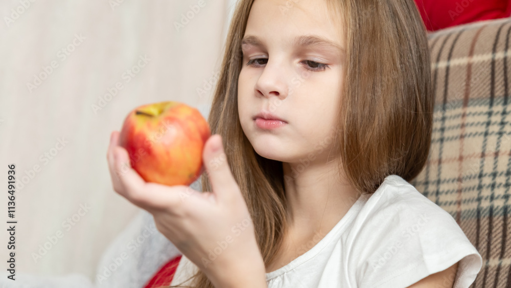 Happy little girl eating apple sitting on the sofa living-room Happy little girl eating apple sitting on the sofa living-room