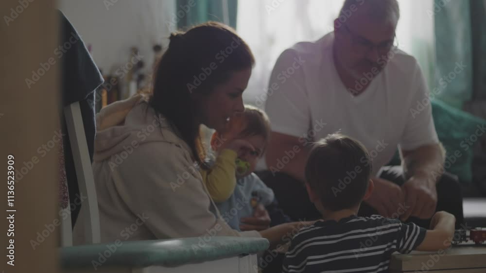 Family spending quality time indoors, parents and children sitting together on the floor, intimate and loving interaction, bonding moment, peaceful and cozy home atmosphere Family spending quality time indoors, parents and children sitting together on the floor, intimate and loving interaction, bonding moment, peaceful and cozy home atmosphere
