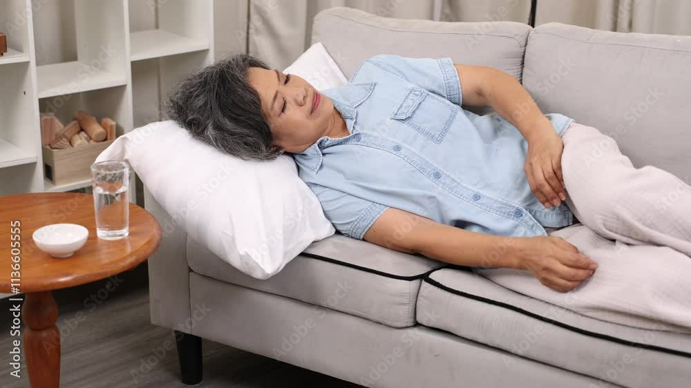 Senior health care headache sick, high blood pressure staying at home alone, woman suffering from migraine ly down on sofa after take medicine, elderly unhealthy experiencing pain get fever Senior health care headache sick, high blood pressure staying at home alone, woman suffering from migraine ly down on sofa after take medicine, elderly unhealthy experiencing pain get fever