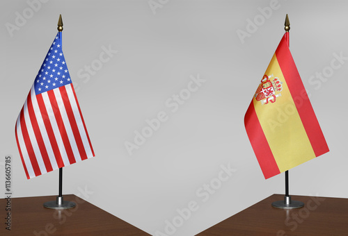 Table flags of USA and Spain on a gray blurred background