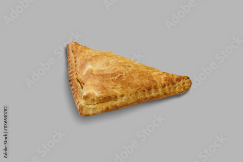 A triangleshaped pastry is set against a gray background surface photo