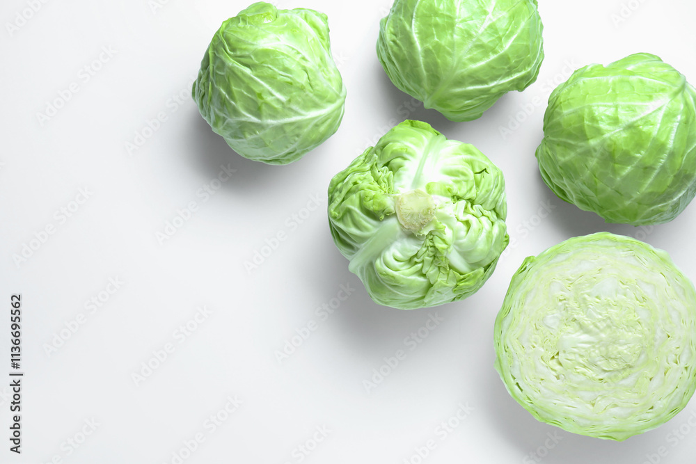 Fototapeta premium Raw green cabbages on white background, flat lay. Space for text