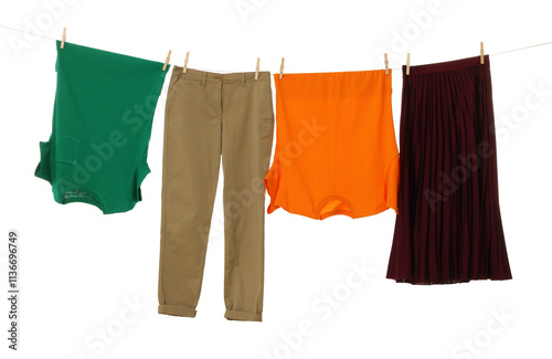 Different clothes drying on laundry line against white background photo