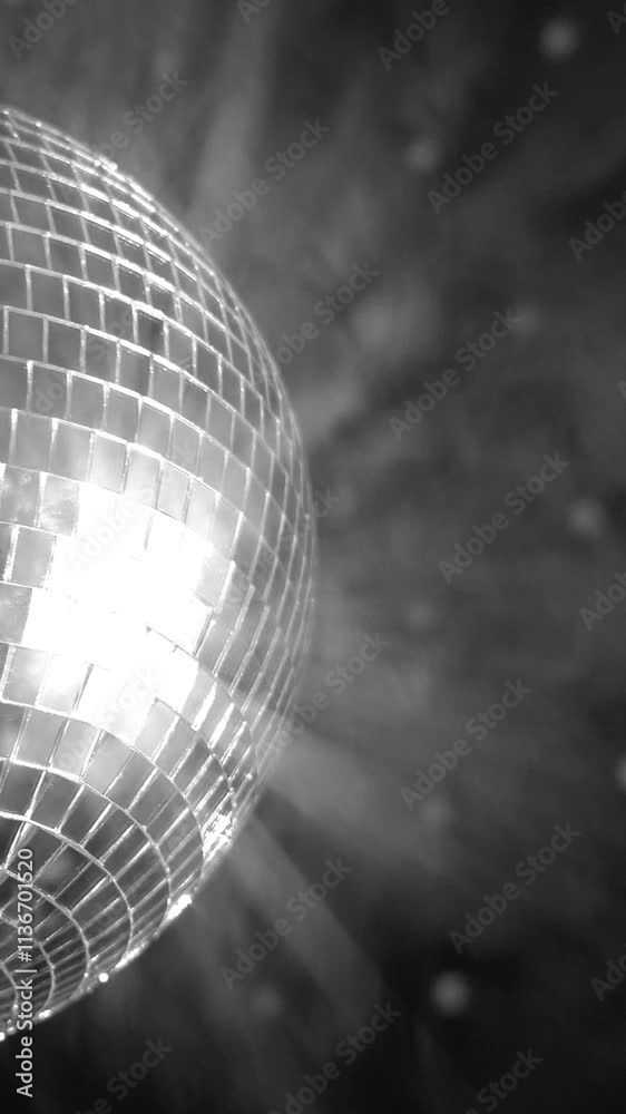 Reflective disco ball spins under bright lights creating a captivating atmosphere in a lively event setting