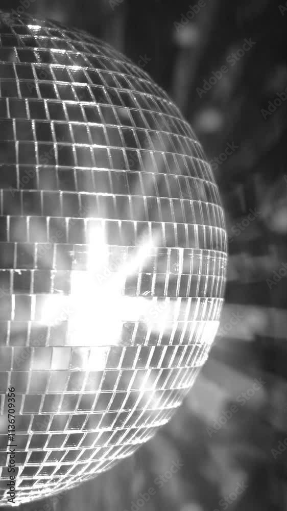 Shimmering silver disco ball reflecting light at a lively party venue during a night celebration