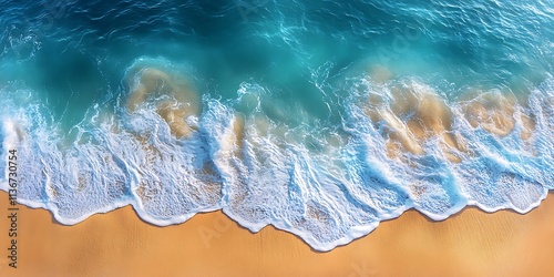 Pristine ocean waves with light foam meeting a smooth, golden beach, viewed from a high aerial angle.