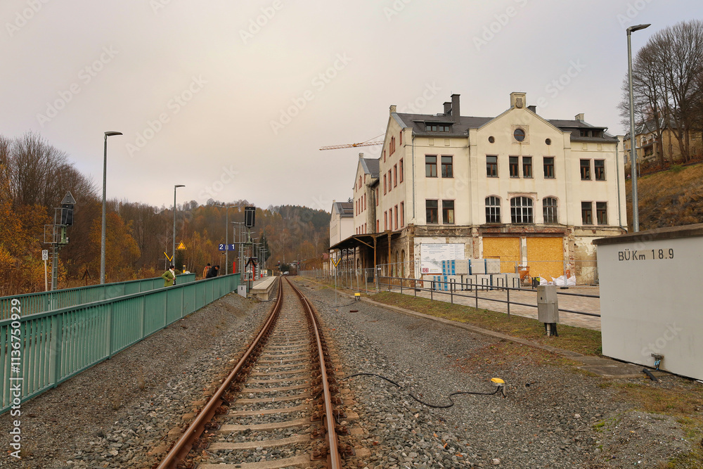 Fototapeta premium Blick entlang der Gleisanlagen auf das historische Empfangsgebäude des Unteren Bahnhofs in Annaberg-Buchholz, Erzgebirgskreis, Sachsen, Deutschland
