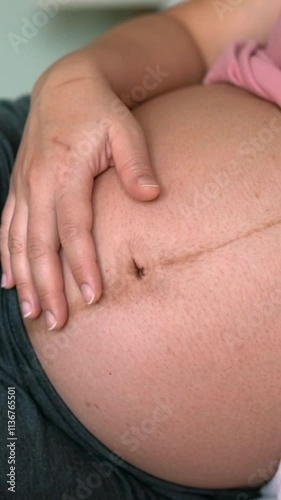 Wallpaper Mural Pregnant woman feeling happy at home while taking care of her child. The young expecting mother holding baby in pregnant belly. Maternity prenatal care and woman pregnancy concept. Torontodigital.ca