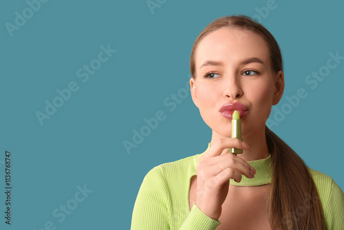 Young woman applying lip ba...
