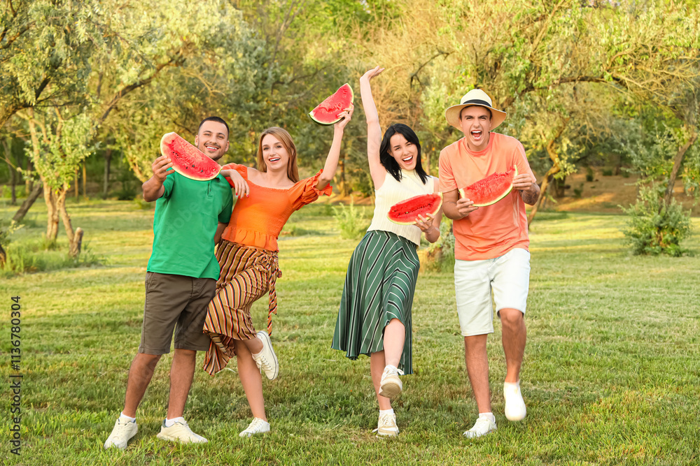 Obraz premium Happy friends with slices of watermelon on picnic in park