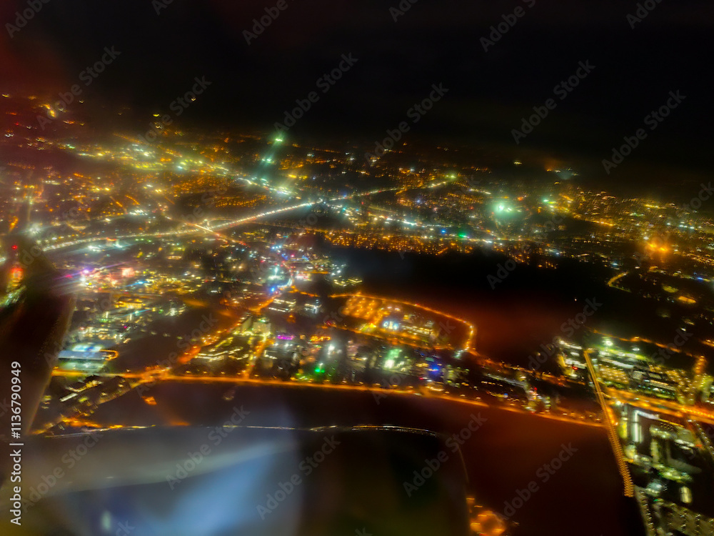 A vibrant aerial view of a city at night showcasing illuminated streets, buildings, and colorful lights against a dark sky. A glowing urban landscape from above. A vibrant aerial view of a city at night showcasing illuminated streets, buildings, and colorful lights against a dark sky. A glowing urban landscape from above.