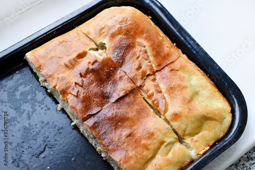 A beautiful and juicy meat pie on a baking sheet. Delicious potato pie.