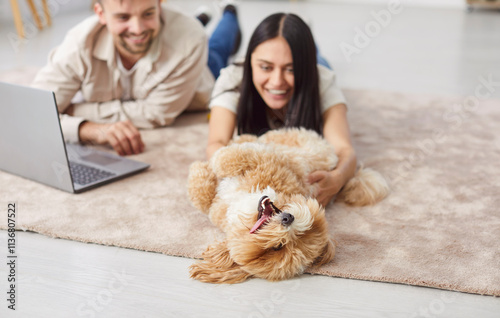 Fotografie Family couple playing with dog at home, enjoying leisure time together