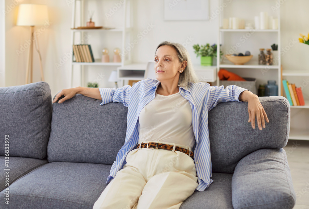 Portrait of a happy senior woman lying comfortably on sofa at home living room, relaxing and enjoying a moment of rest. Joyful and peaceful life of a pensioner in cozy domestic living space. Portrait of a happy senior woman lying comfortably on sofa at home living room, relaxing and enjoying a moment of rest. Joyful and peaceful life of a pensioner in cozy domestic living space.