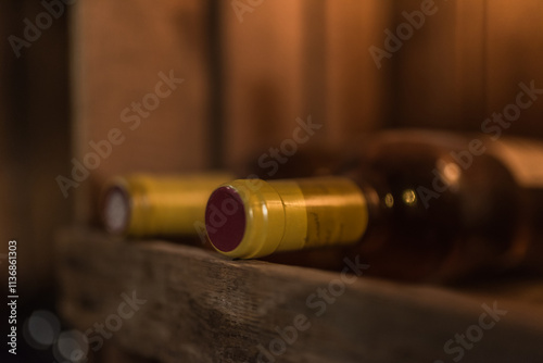 Close-up of Two bottles of red wine lying on wooden wine rack photo