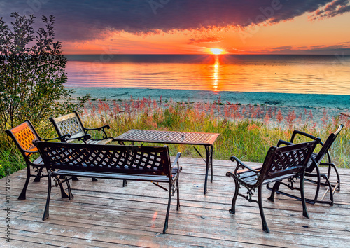 Seascape with resting and relaxing site with wooden floor and tables and gard...