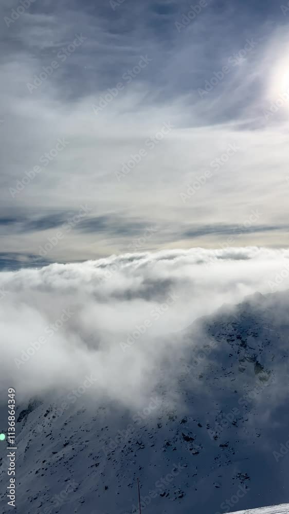 Mountain peak under the clouds and fog in French alps by winter Mountain peak under the clouds and fog in French alps by winter