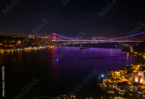 Anadolu Hisari (Anatolian Fortress) Fatih Sultan Mehmet Bridge Bosphorus Bridge at Night with Illuminated Cityscape.An aerial view of the Bosphorus Bridge at night, showcasing its illuminated structu photo