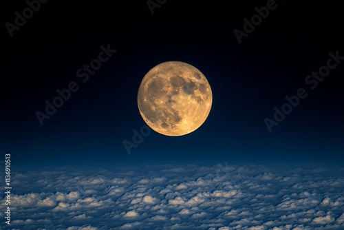 Full moon over a layer of clouds at night.