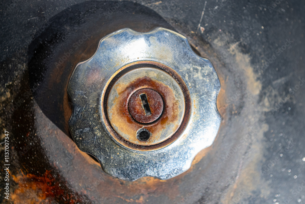 The locked and rusted gas tank cap of an old motorcycle. The locked and rusted gas tank cap of an old motorcycle.