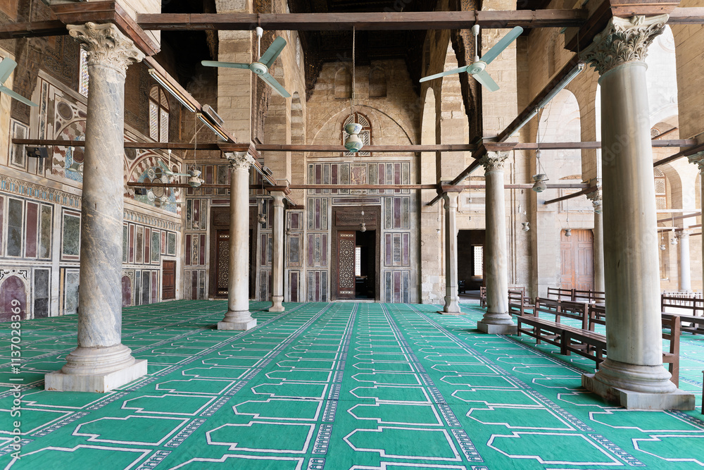 Fototapeta premium Ornate interior of Sultan al-Muayyad Mosque with green patterned carpet.