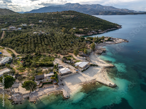 An aerial view of Ksamil resort village surrounded by blue waters and majestic mountains. Albania