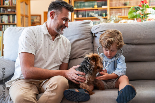 Father and son bonding with a dog on a cozy sofa at home photo