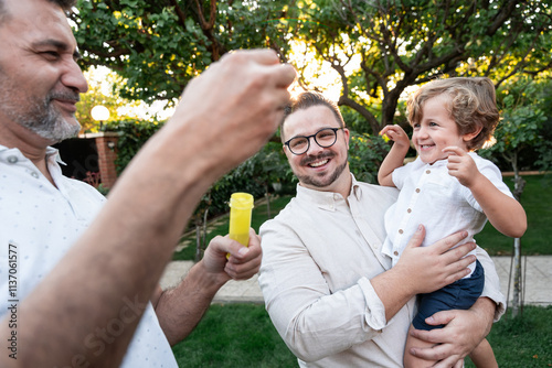 Loving gay couple enjoying a playful moment with their son photo