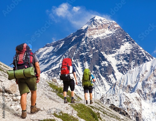 Photography Mount Everest as seen from gokyo valley and three hikers