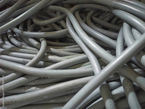 chaotic pile of electric cable in grey insulation as background