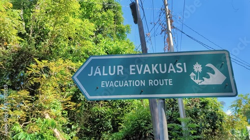 Street view of Jalur Evakuasi Evacuation Route sign on tropical island of Pulau Weh in Aceh Province of Indonesia