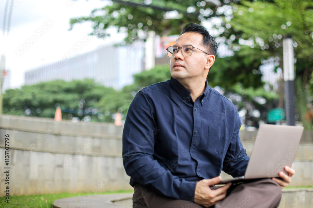 Portrait of Businessman Working Using Laptop While Sitting on Bench Portrait of Businessman Working Using Laptop While Sitting on Bench