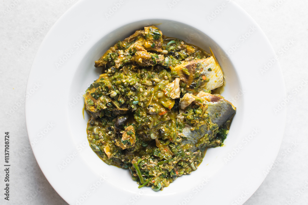 Overhead view of Nigerian okro vegetable soup in a white plate, top view of okro soup in a soup plate Overhead view of Nigerian okro vegetable soup in a white plate, top view of okro soup in a soup plate