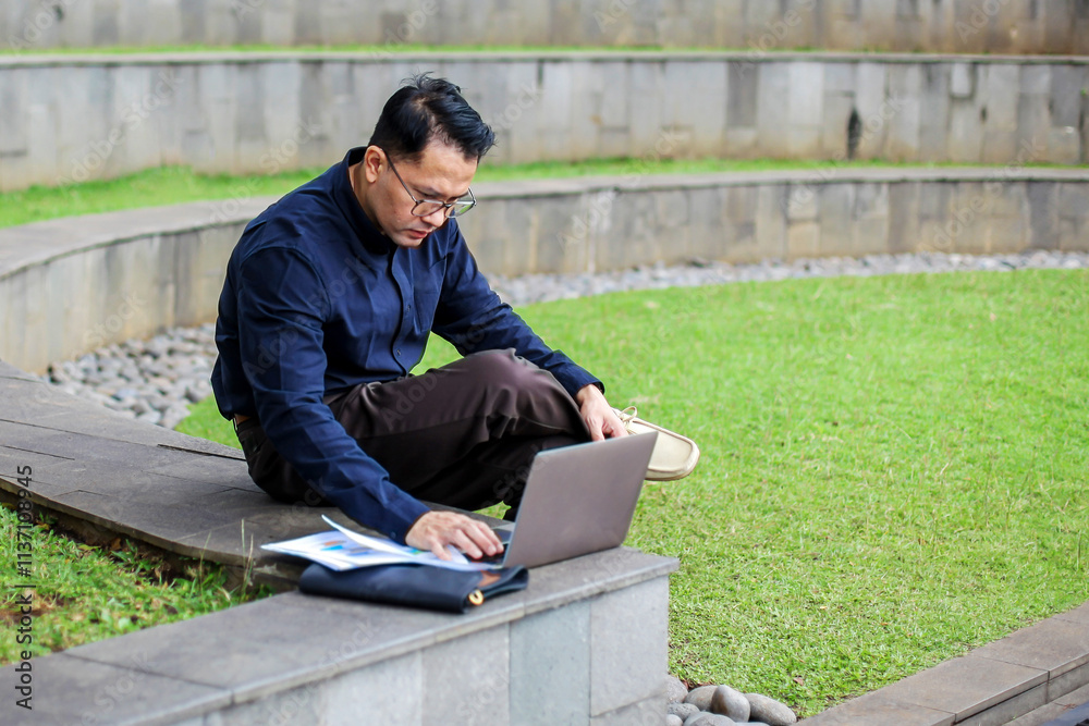 Man Wearing Formal Clothes Working Using Laptop While Sitting on Bench