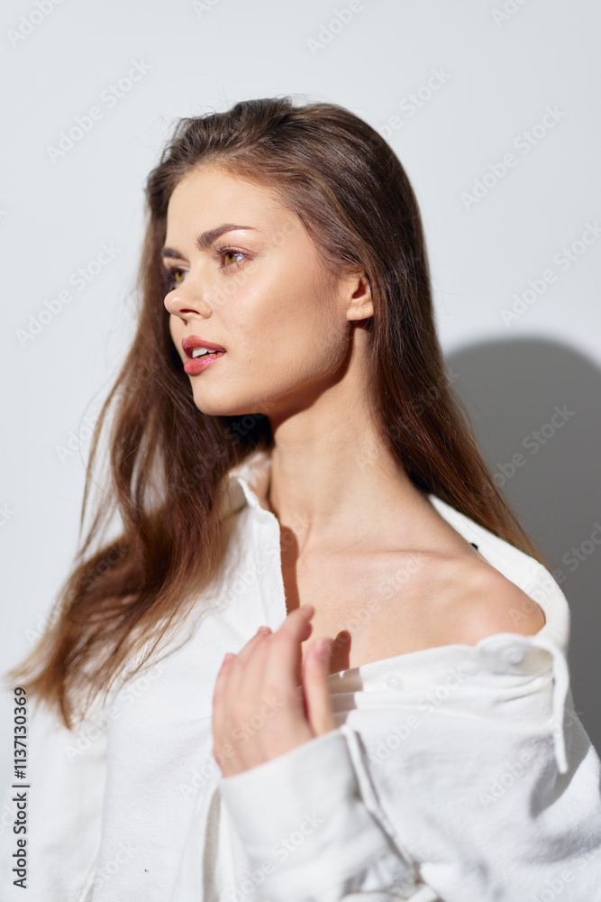 Portrait of a young woman with natural beauty, wearing a white shirt, standing against a light background, showcasing elegance and confidence while highlighting soft facial features Portrait of a young woman with natural beauty, wearing a white shirt, standing against a light background, showcasing elegance and confidence while highlighting soft facial features