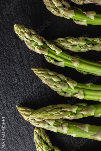 Green asparagus on a black background with copy space