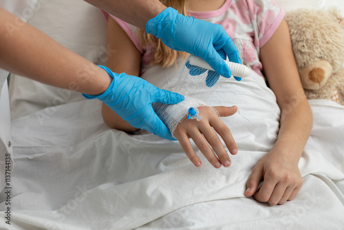 A child is receiving essential medical treatment while resting in a hospital bed today