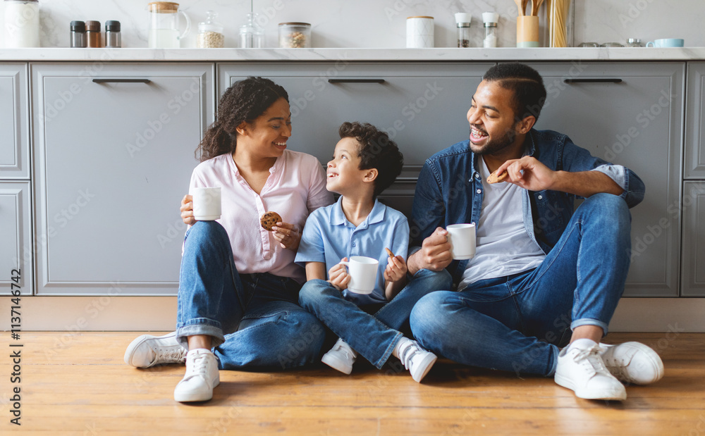 A joyful family spends quality time together in the kitchen. The parents share laughter with their son while enjoying snacks and drinks in a cozy home setting. A joyful family spends quality time together in the kitchen. The parents share laughter with their son while enjoying snacks and drinks in a cozy home setting.