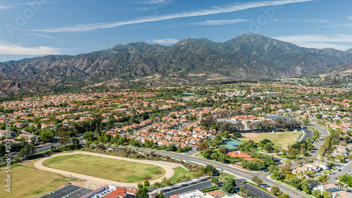 Fototapeta Naklejka Na Ścianę i Meble -  Aerial view of Rancho Santa Margarita showcasing suburban homes and Saddleback Mountains in Southern California