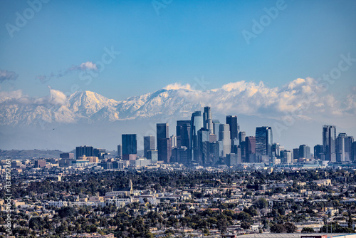 View over Los Angeles Skyline in California with snow covered mountains in the background. Visible are San Gabriel and San Bernardino mountains.  photo