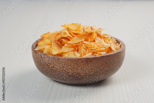 Spicy cassava chip chili sauce in a wooden bowl photographed with studio light with a wooden theme