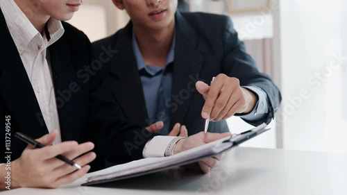 Close up of two business partners reviewing and discussing the terms of document during a meeting